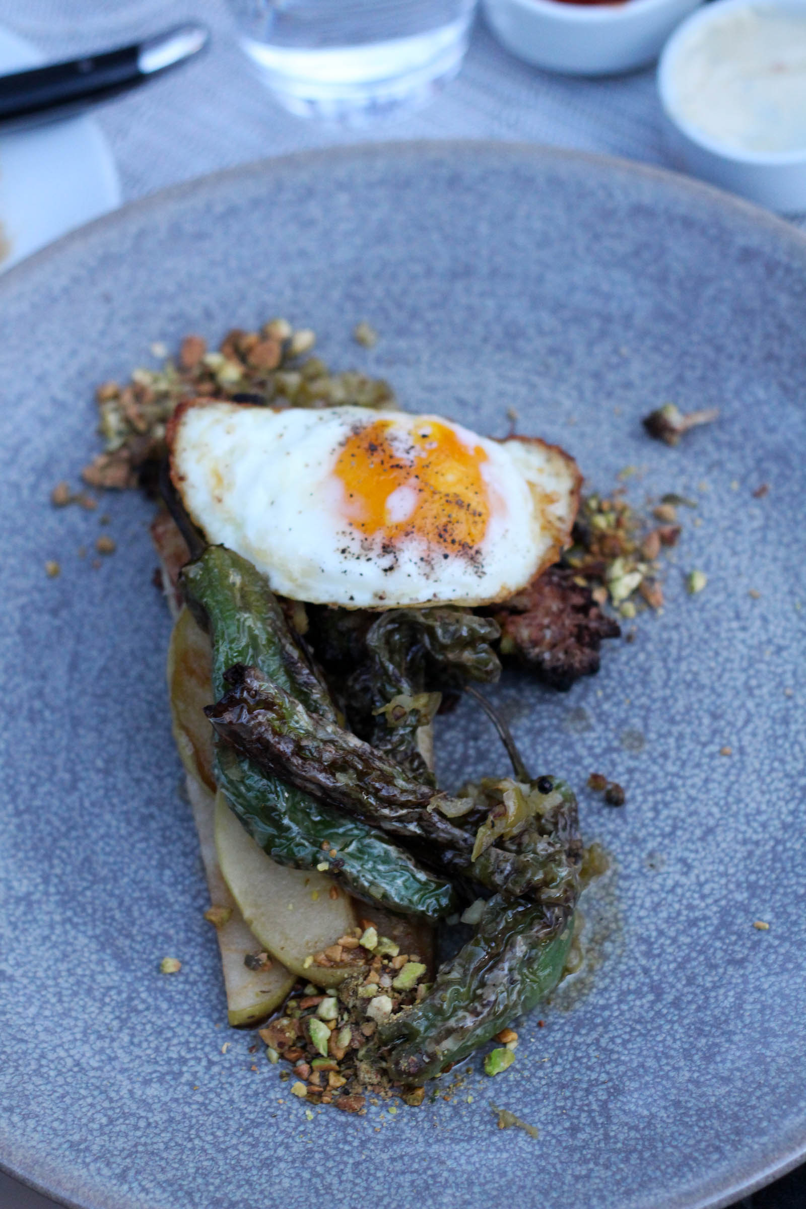 cauliflower steak and egg with shishito vinaigrette, maple apples, and pistachio