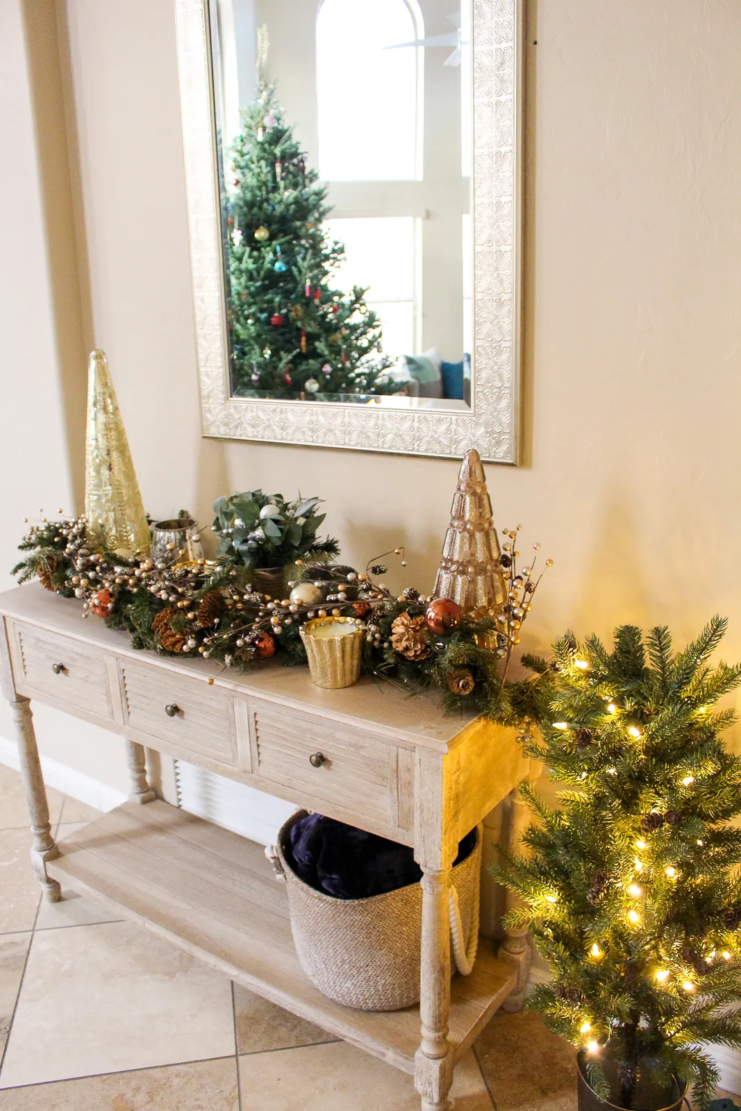 End table with bronze and gold holiday decorations, gold Christmas trees and candles