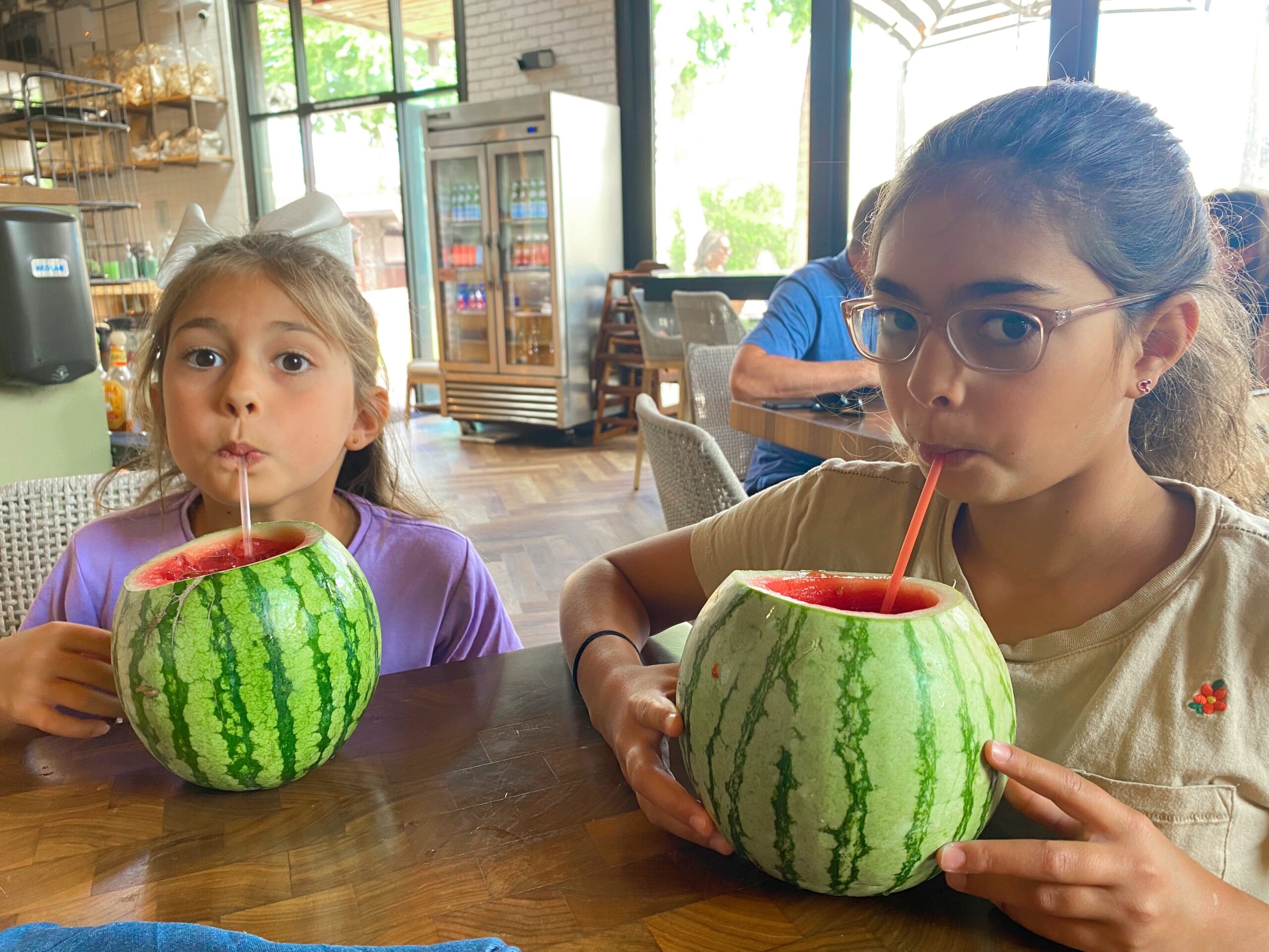 little girls drinking from watermelon